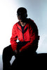A man in a red jacket is sitting down