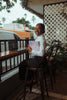 Young woman smiling with books and laptop at cafe