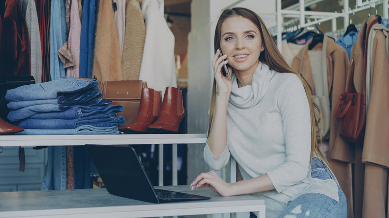 Woman talks on the phone while using a laptop