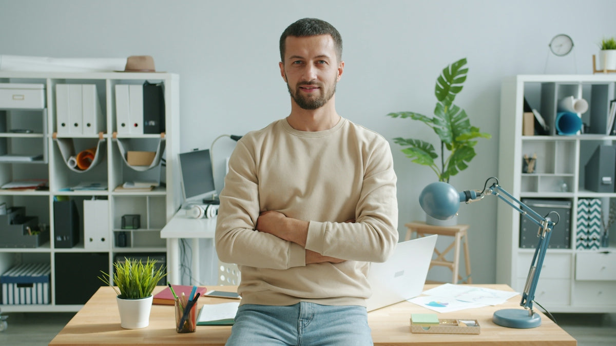 Man with arms crossed in modern office workspace