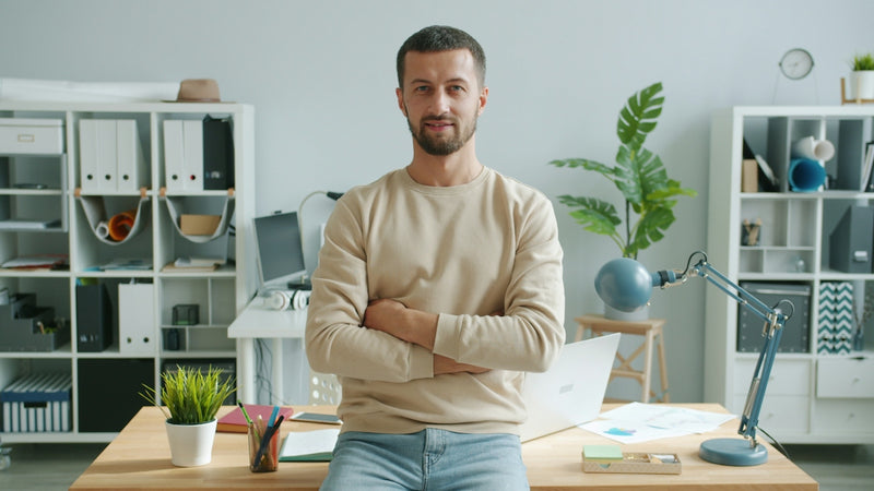 Man with arms crossed in modern office workspace