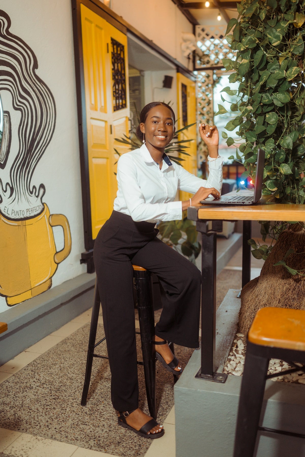 A woman smiling while working on a laptop.