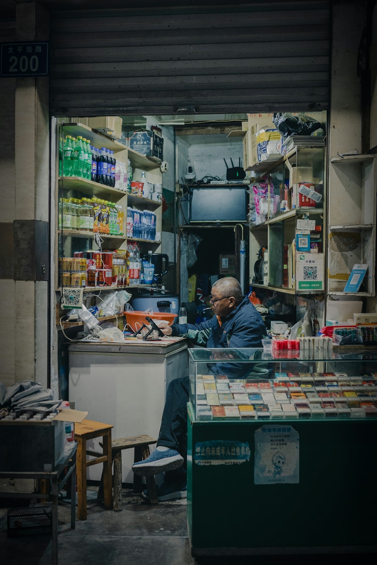 Elderly man smoking inside a small convenience store