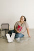 Smiling woman on floor with storage items and a book