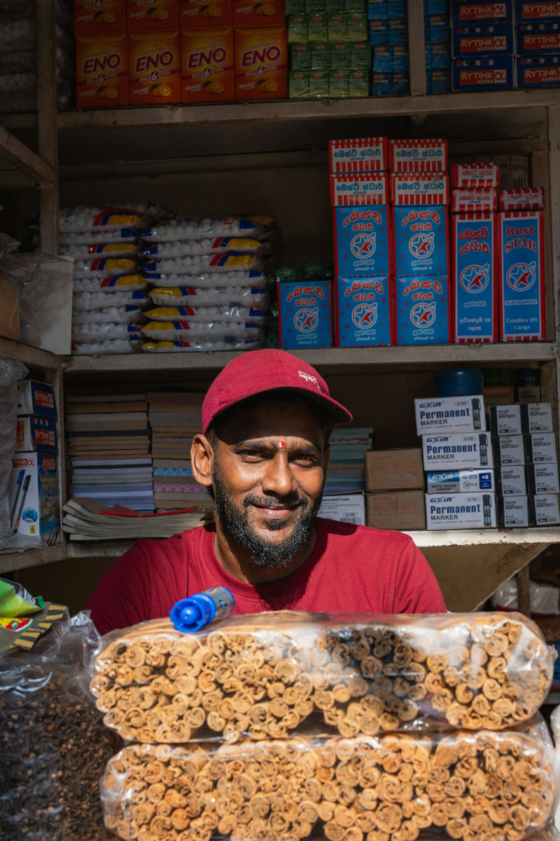 A man smiles behind a counter in a small shop