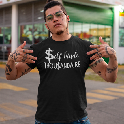 Self-Made Thousandaire T-Shirt | Entrepreneurs on the Rise worn by young man with tattoos outdoors.