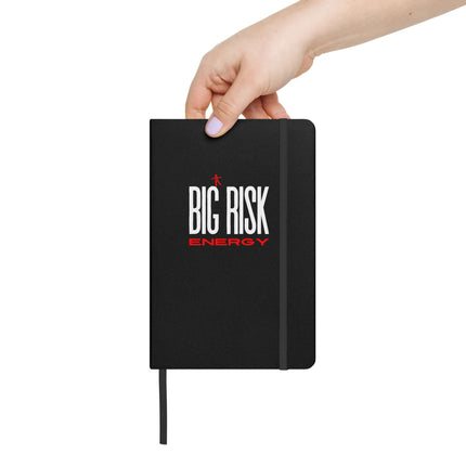 Big Risk Energy Notebook – Bold Journal for Visionaries held in a hand with a sleek black cover and elastic closure.