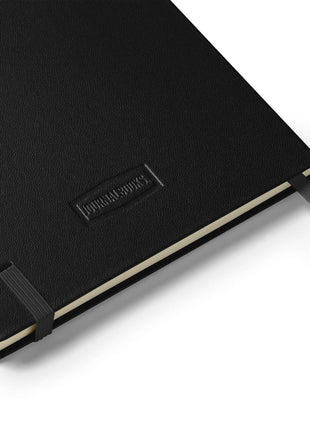 Black UltraHyde hardcover notebook with elastic closure, featuring cream-colored lined pages and ribbon bookmarks.