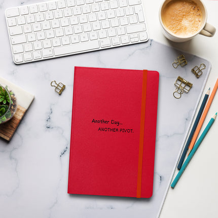 Another Day, Another Pivot Notebook – Agile Journal for Creative Entrepreneurs on a desk with coffee.