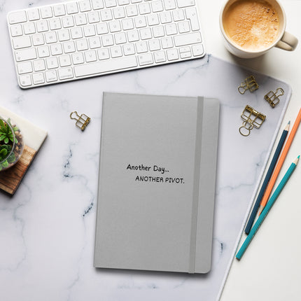Another Day, Another Pivot Notebook – Agile Journal for Creative Entrepreneurs on a desk with coffee and stationery.